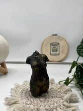Load image into Gallery viewer, Decorative elements including a textured wall piece, plant, and small body figurine on a white surface.
