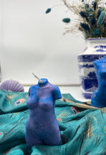 Load image into Gallery viewer, Blue female torso candle on a textured surface with a vase in the background
