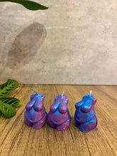 Load image into Gallery viewer, Three purple and blue candles shaped like buttocks on a wooden surface with a light background.

